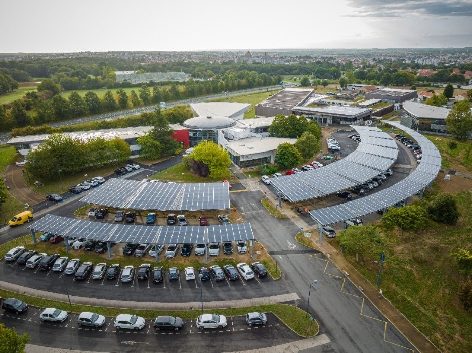 Vue aérienne d'ombrières photovoltaïques couvrant les parkings d'un site d'entreprise